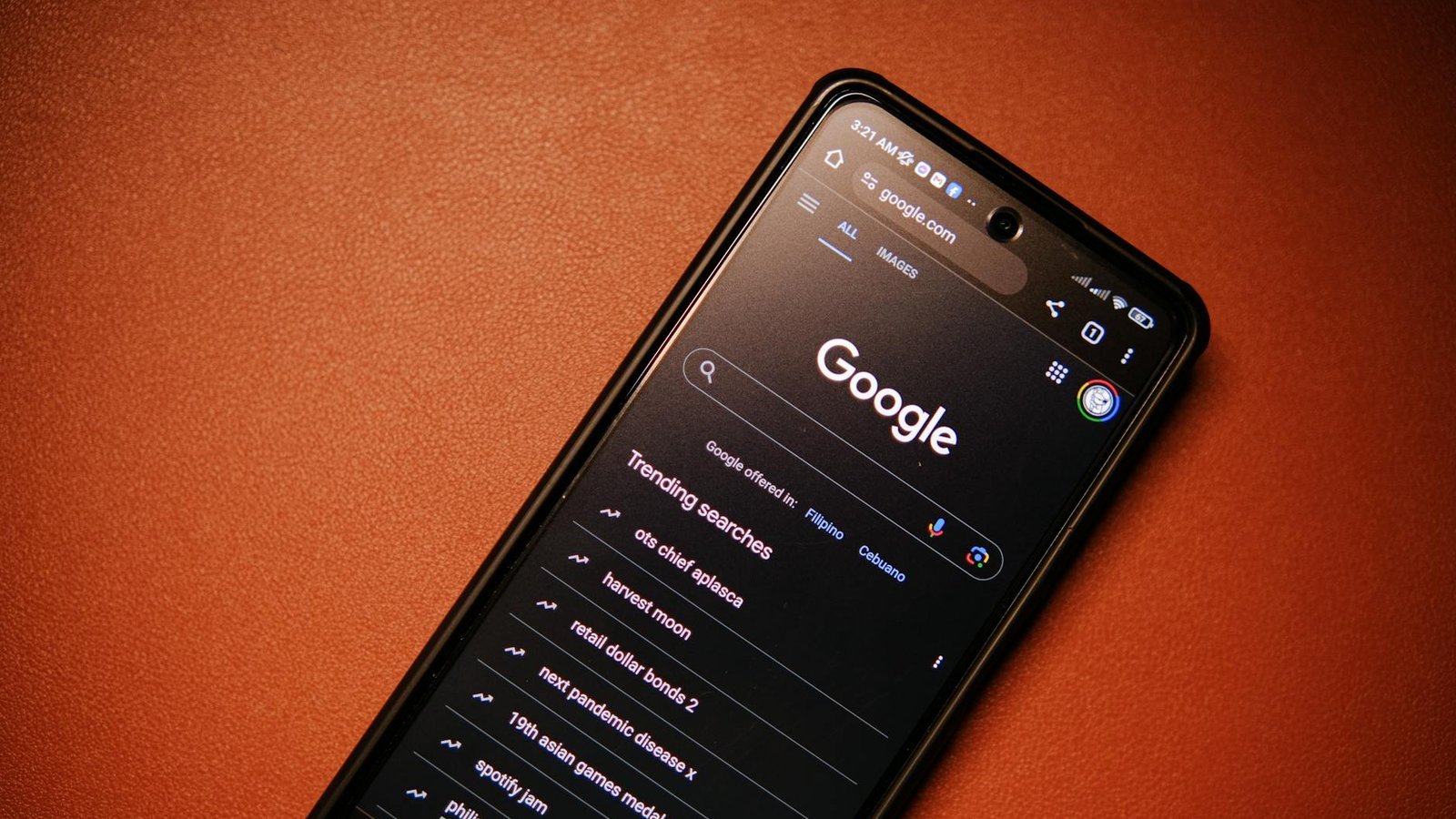 A smartphone displaying Google Search trends on a table at night.