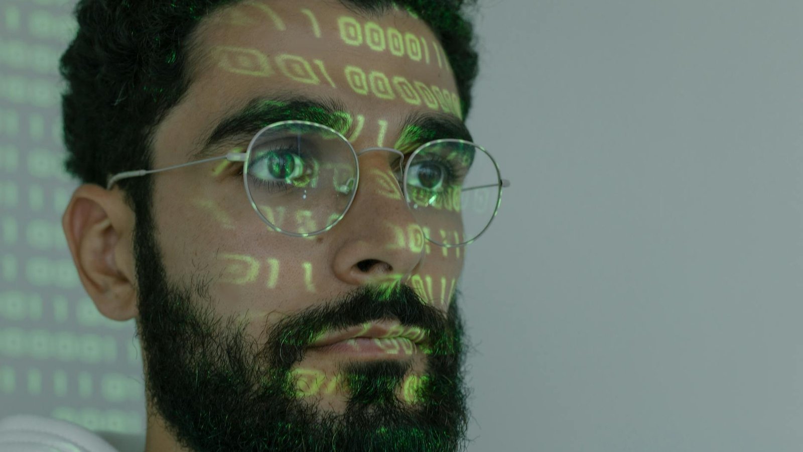 Claude Mythos Anthropic – code binaire vert projeté sur visage développeur