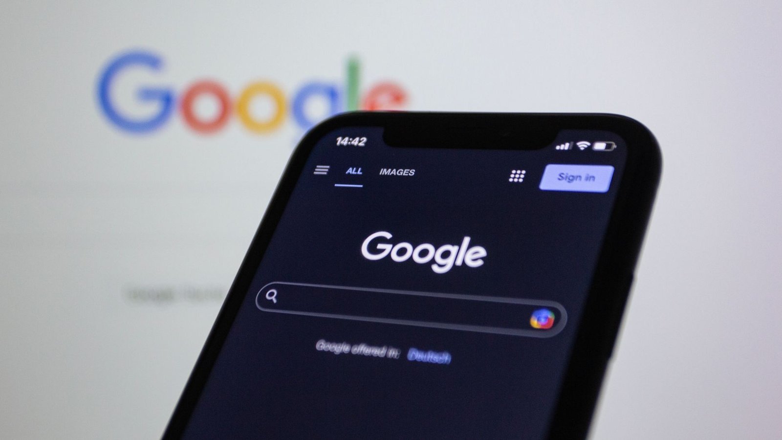 Google sur smartphone en mode sombre, arnaque réseau criminel