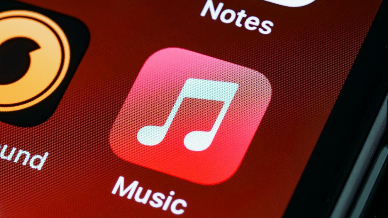 Detailed close-up of an iPhone home screen featuring the music app icon.