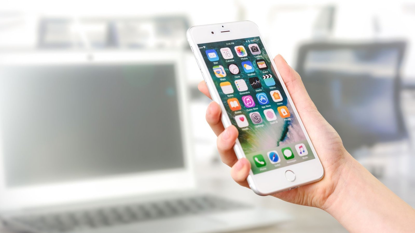 iOS 27 – iPhone tenu en main avec écran d'accueil Apple