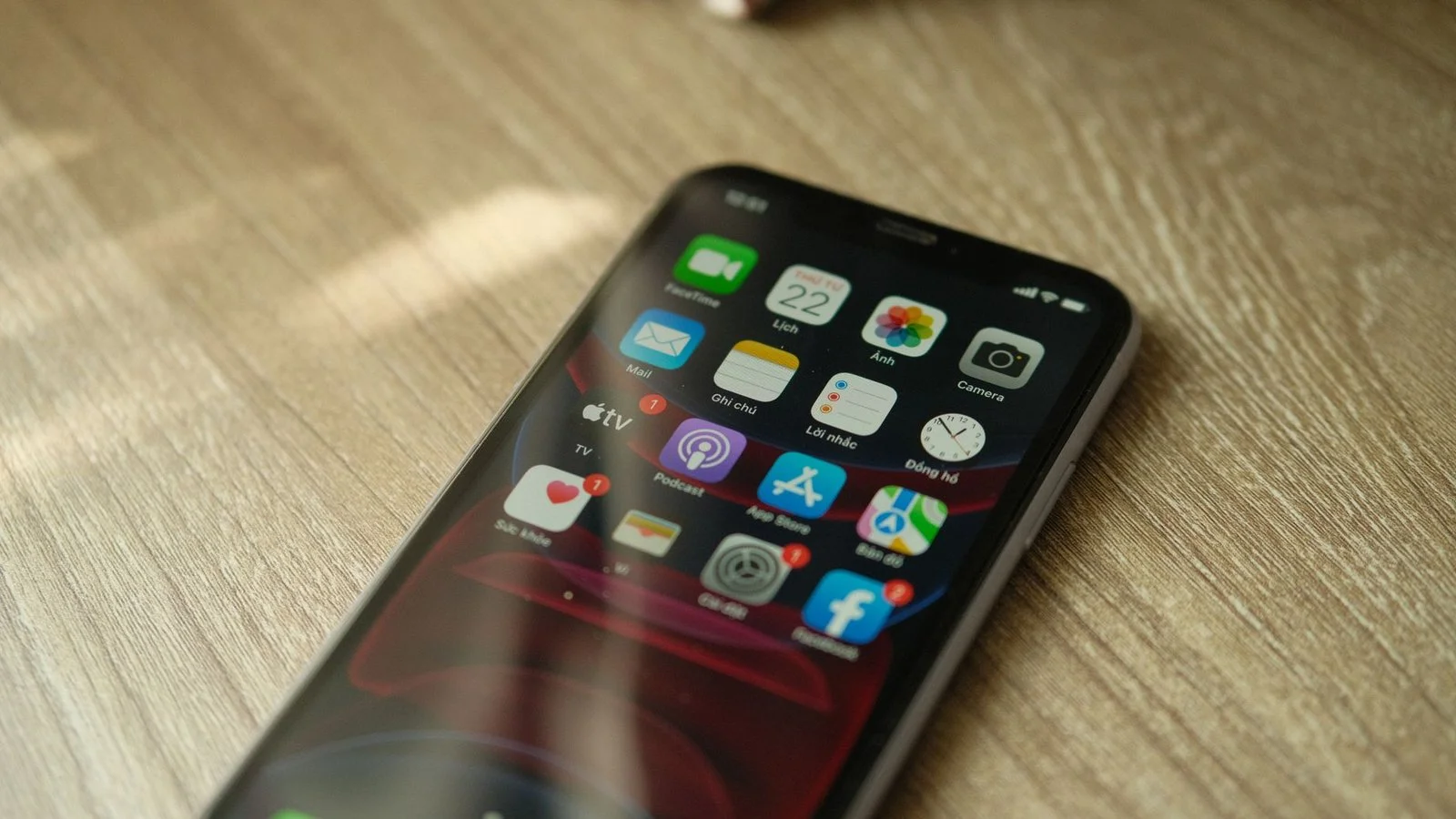 Applications iPhone sur écran avec wallpaper rouge sur bureau