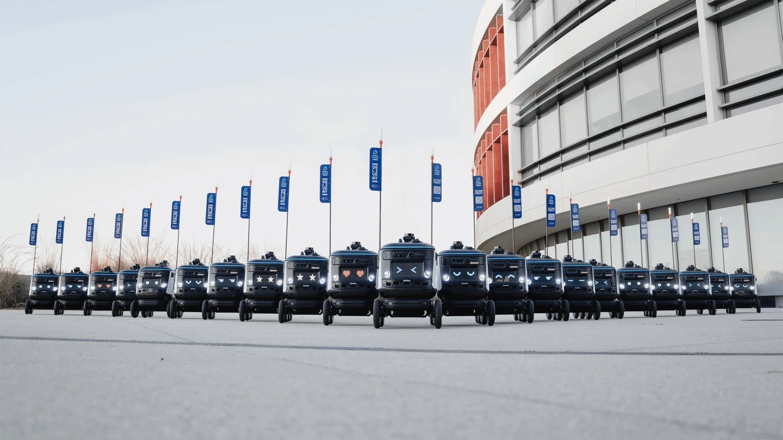 Robots autonomes déployés en flotte devant un bâtiment industriel