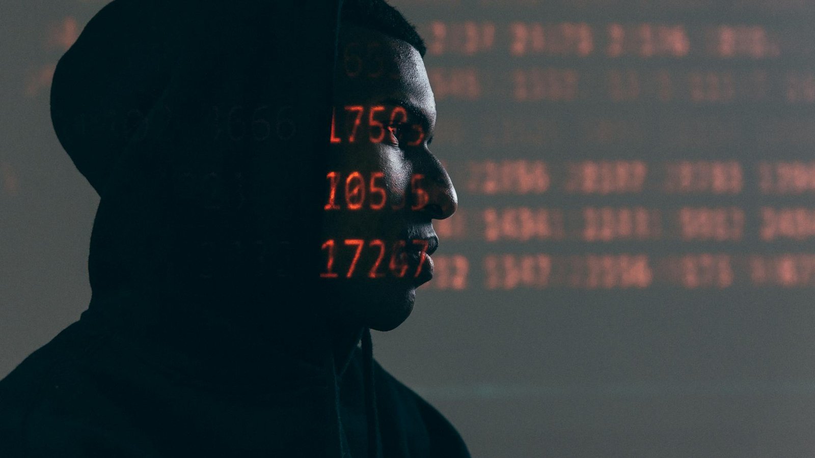 Leaker zero-day – hacker anonyme avec code rouge projeté