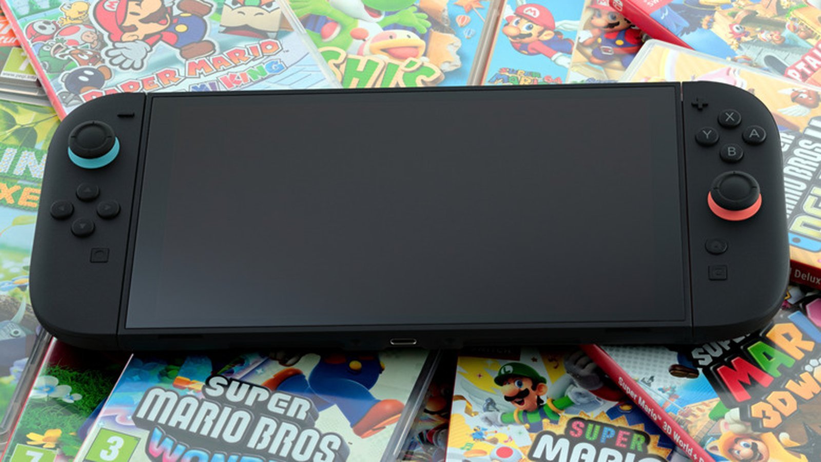 Nintendo Switch 2 vue de face posée sur boîtes de jeux Super Mario