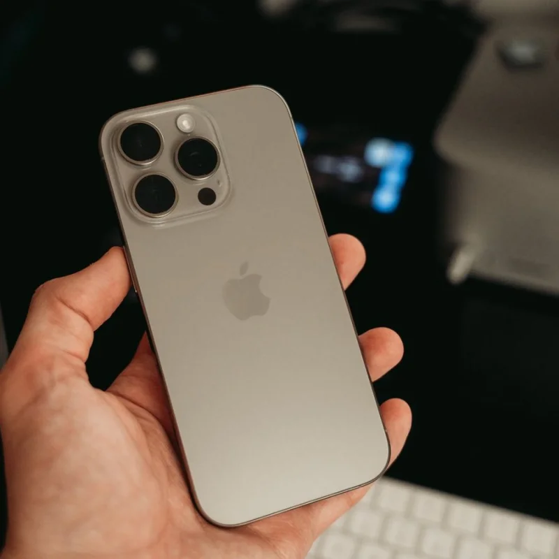 iPhone Pro design dos en verre et titane tenu en main