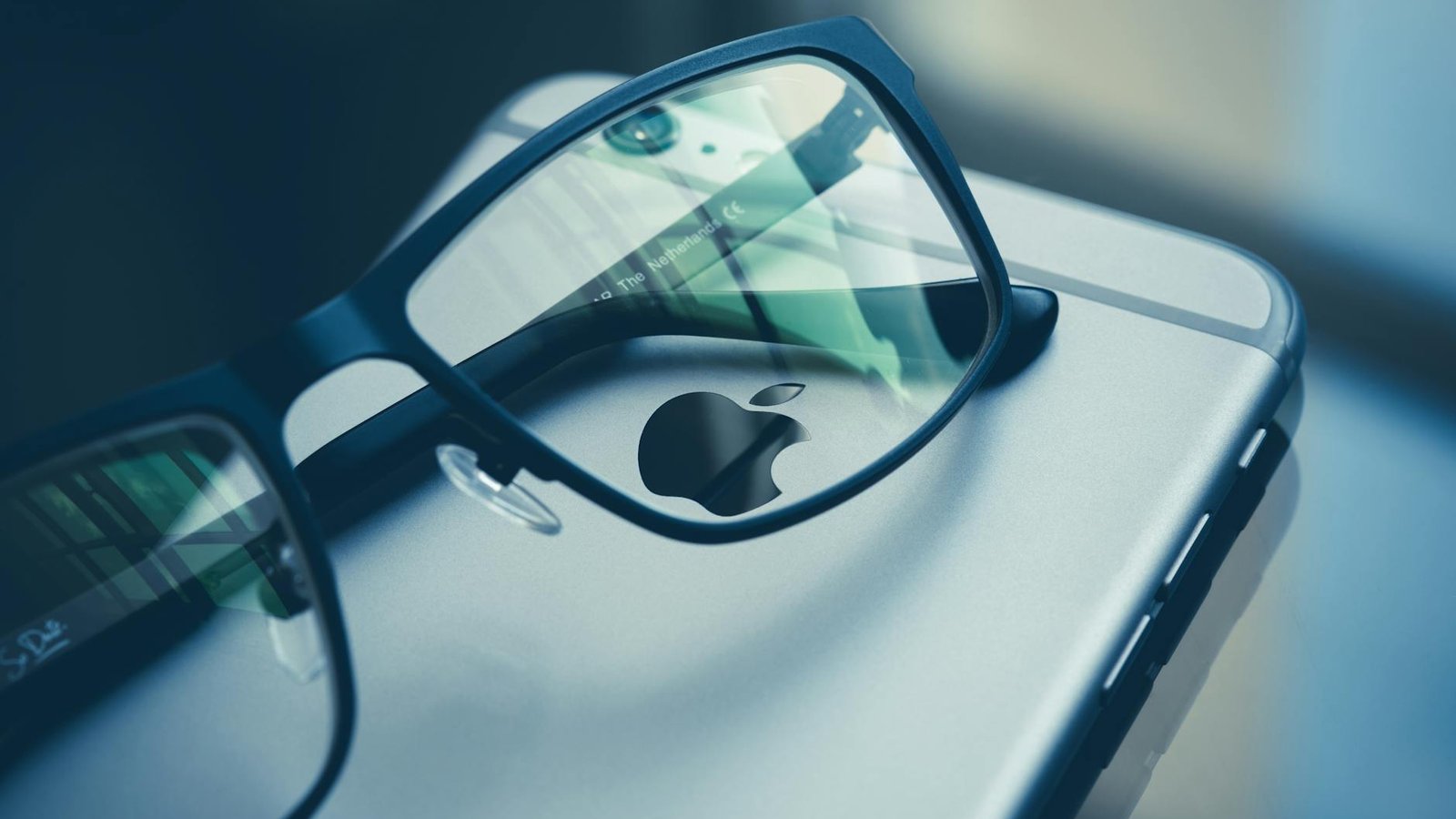 Close-up photo of eyeglasses placed over a smartphone, highlighting technology and style.