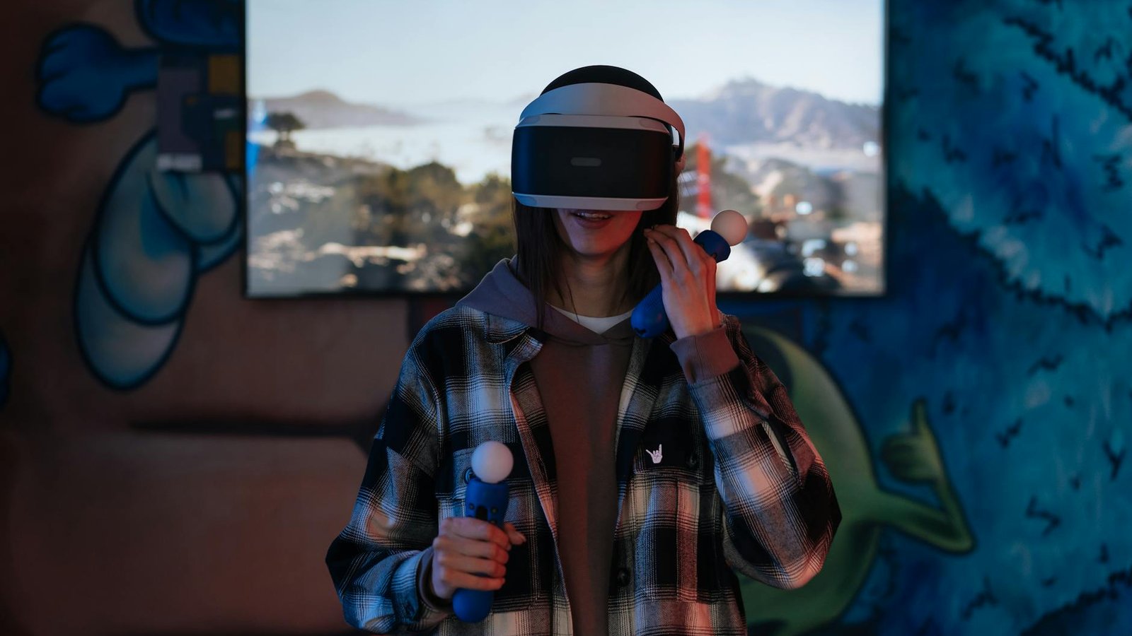 A young woman immersed in a virtual reality experience using VR goggles and controllers indoors.