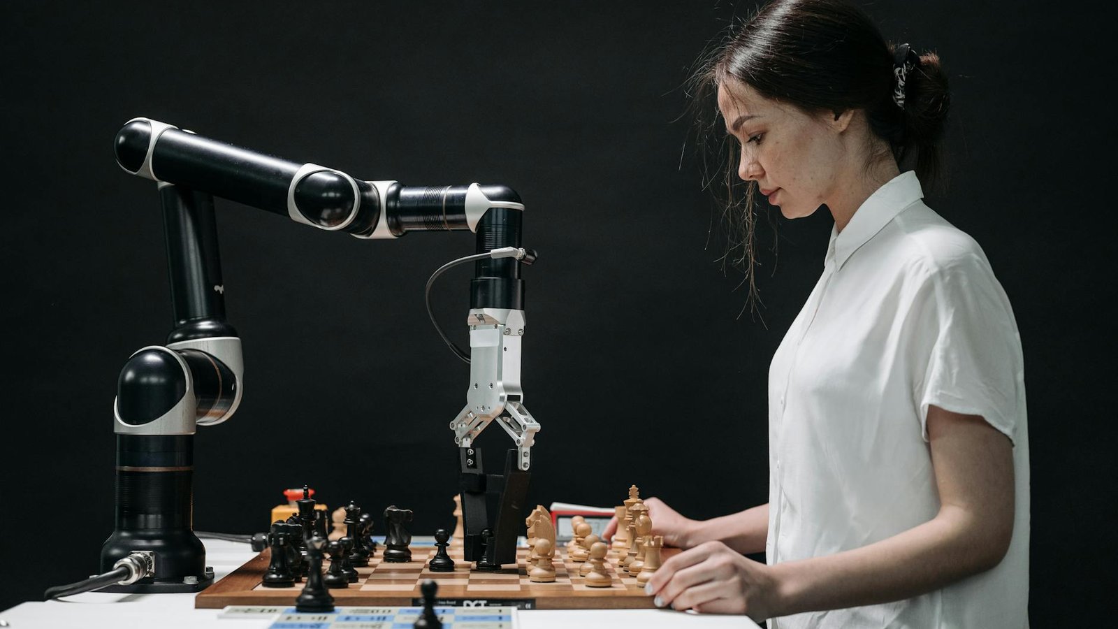 Claude IA malveillante — femme face à bras robotique sur échiquier