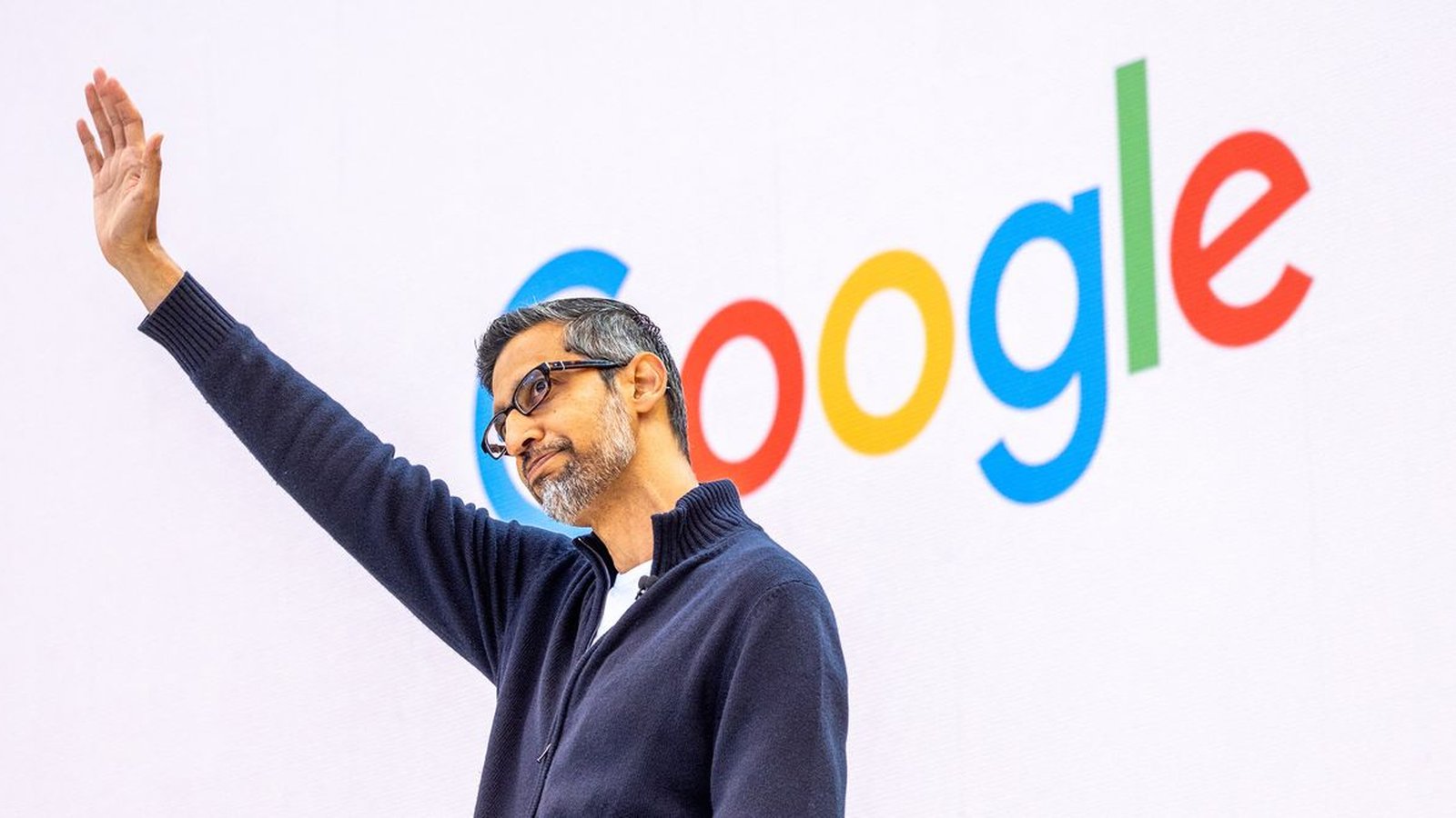 Keynote Google I/O orateur saluant devant logo Google