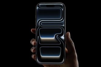 iPhone Pro tenu en main avec animation graphique sur l'écran fond noir