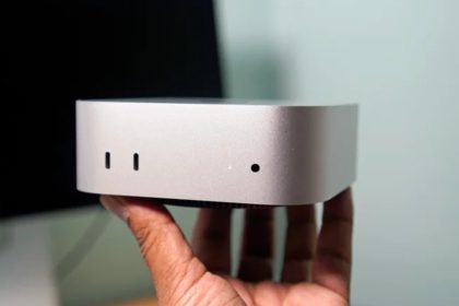 Mac mini Apple tenu en main, façade avant avec ports USB-C