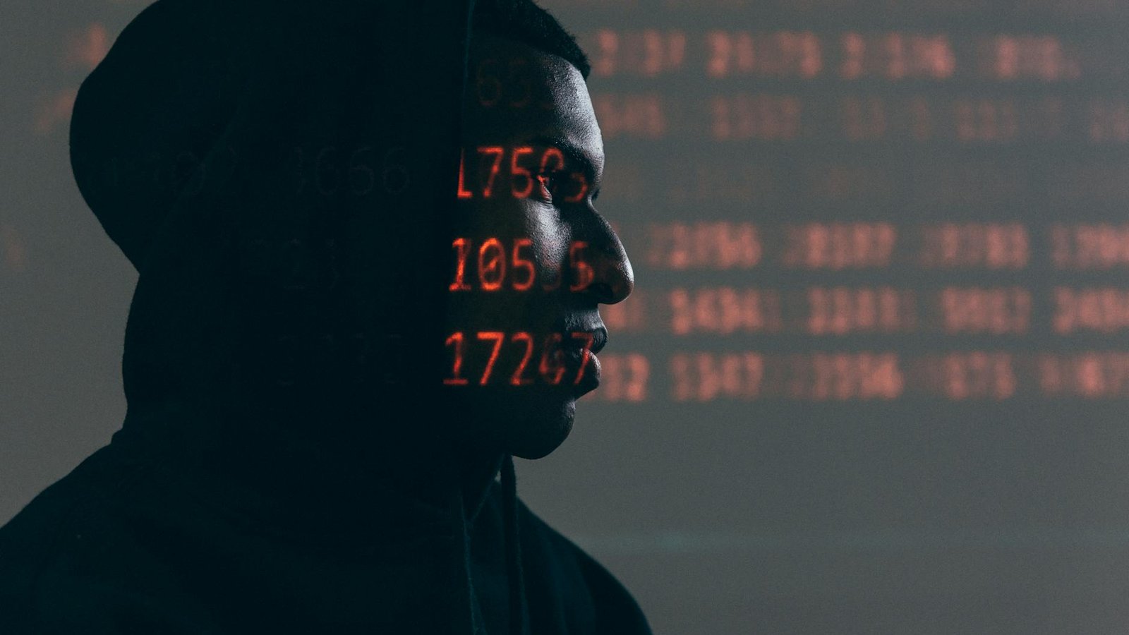 Leaker zero-day – hacker anonyme avec code rouge projeté