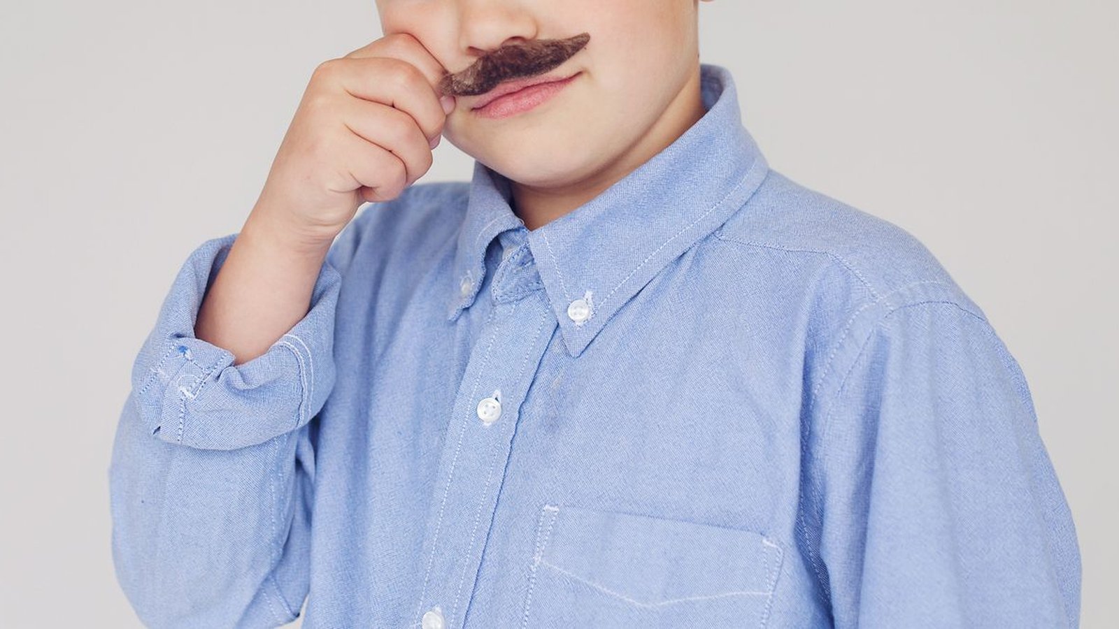 Vérification d'âge Instagram : enfant portant fausse moustache, plan rapproché