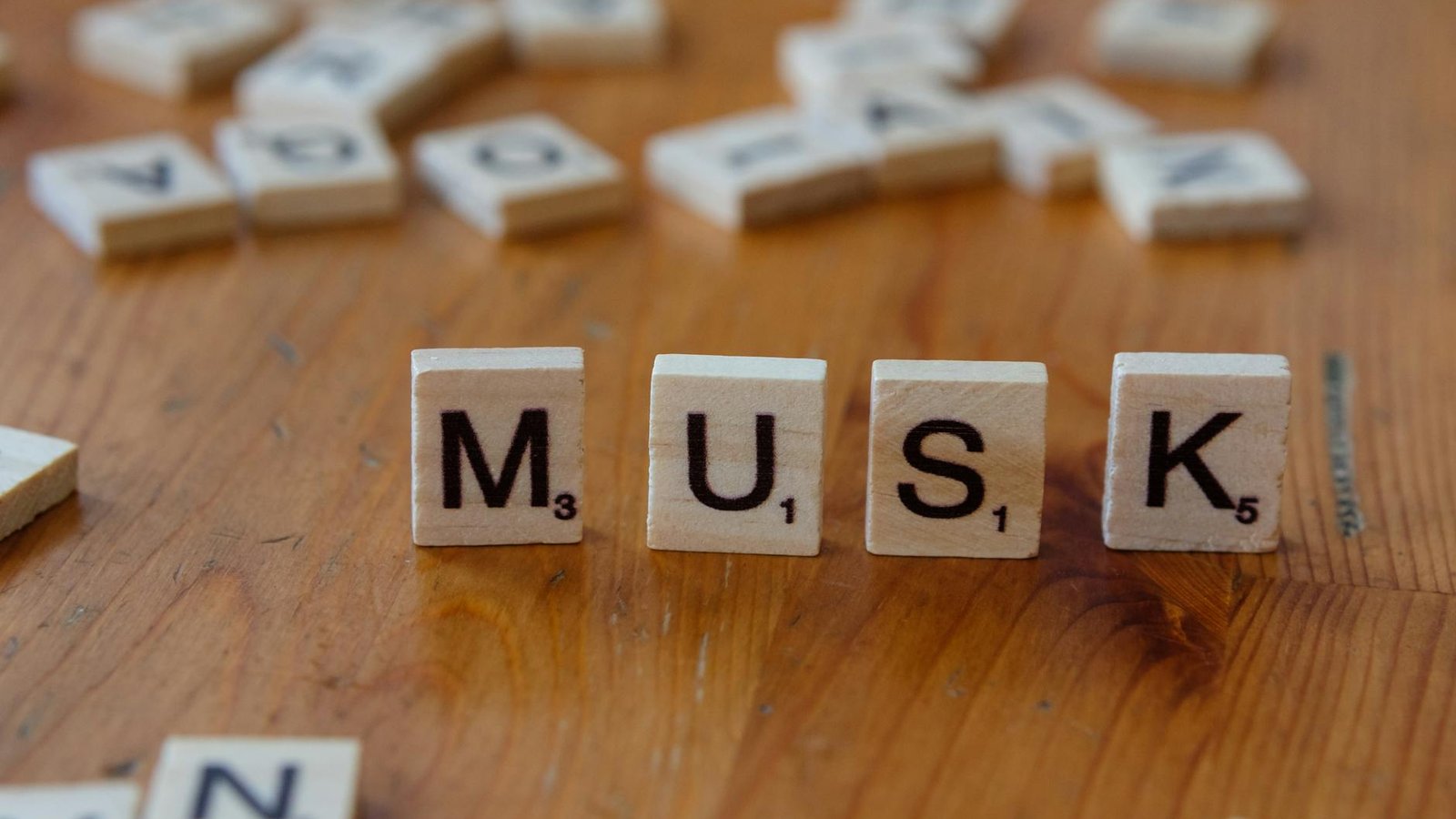Elon Musk procès OpenAI – tuiles Scrabble formant MUSK sur bois