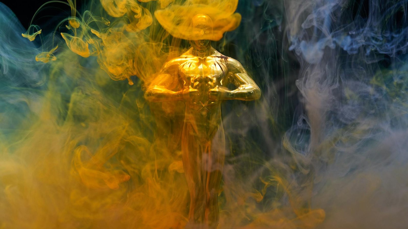 Oscars statuette dorée entourée de fumée colorée