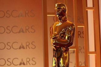 Statuette Oscars dorée devant panneau officiel académie cinéma