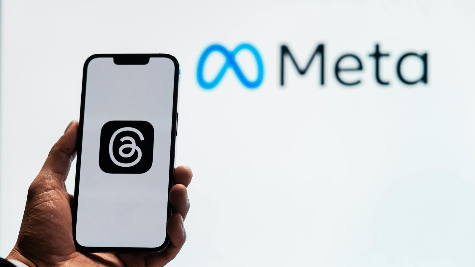Application Meta Threads sur smartphone fond logo Meta blanc
