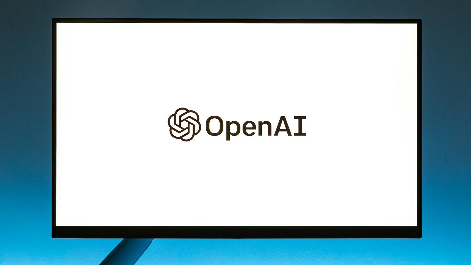Puce IA OpenAI — logo OpenAI sur écran billboard fond bleu