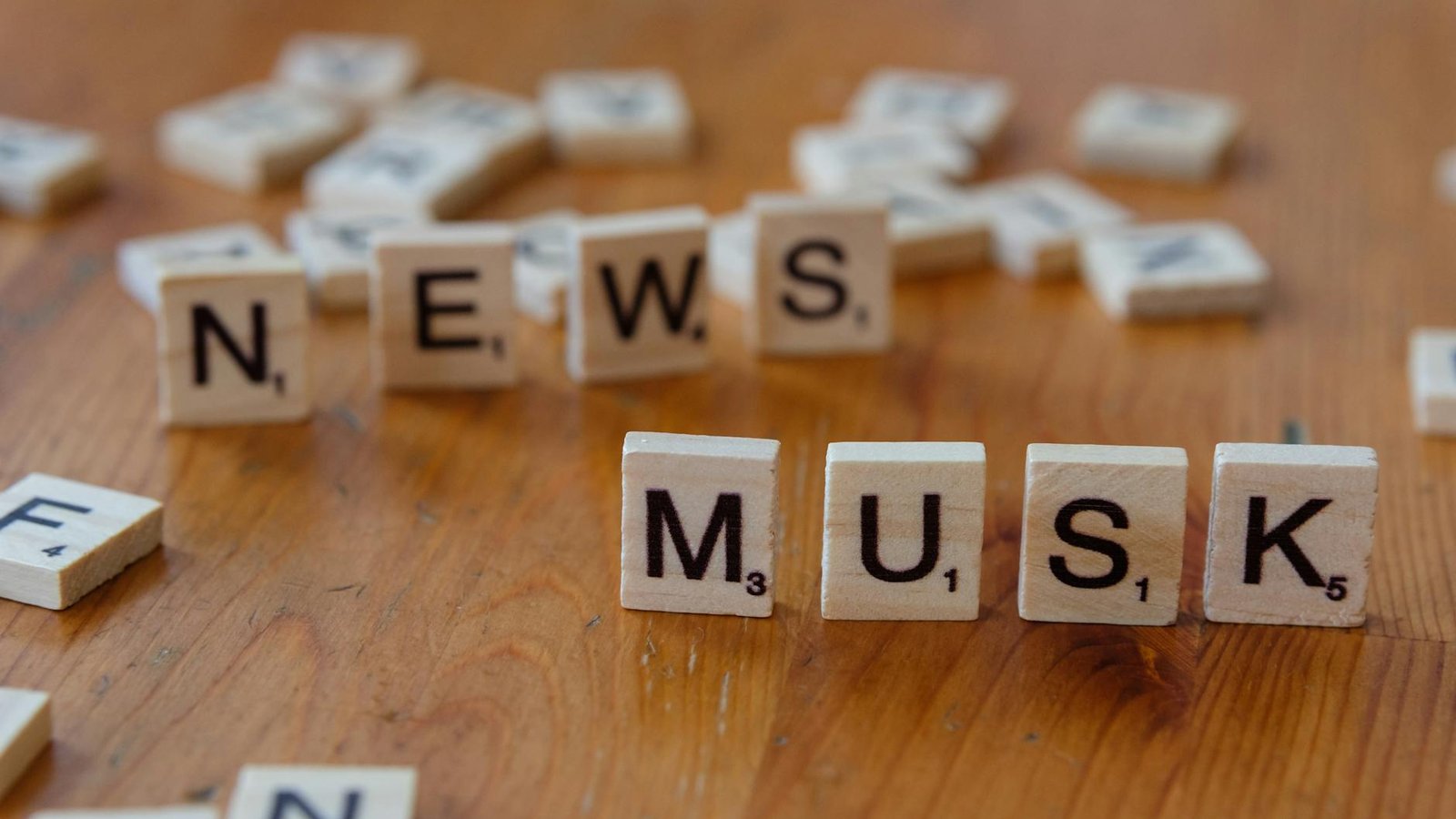 Procès Musk OpenAI : tuiles Scrabble formant NEWS MUSK