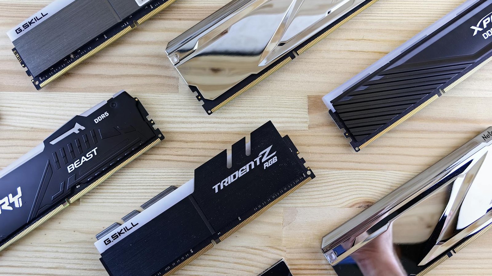 Barrettes RAM G.Skill Trident Z et Kingston DDR5 sur surface en bois