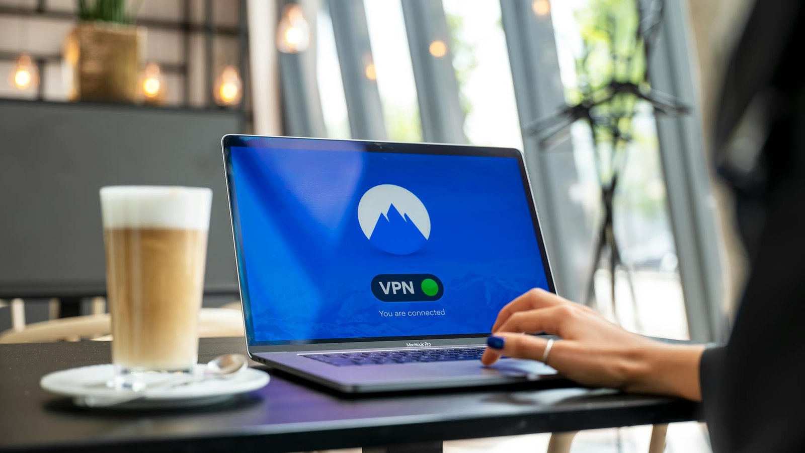 VPN activé sur laptop en café, connexion sécurisée NordVPN