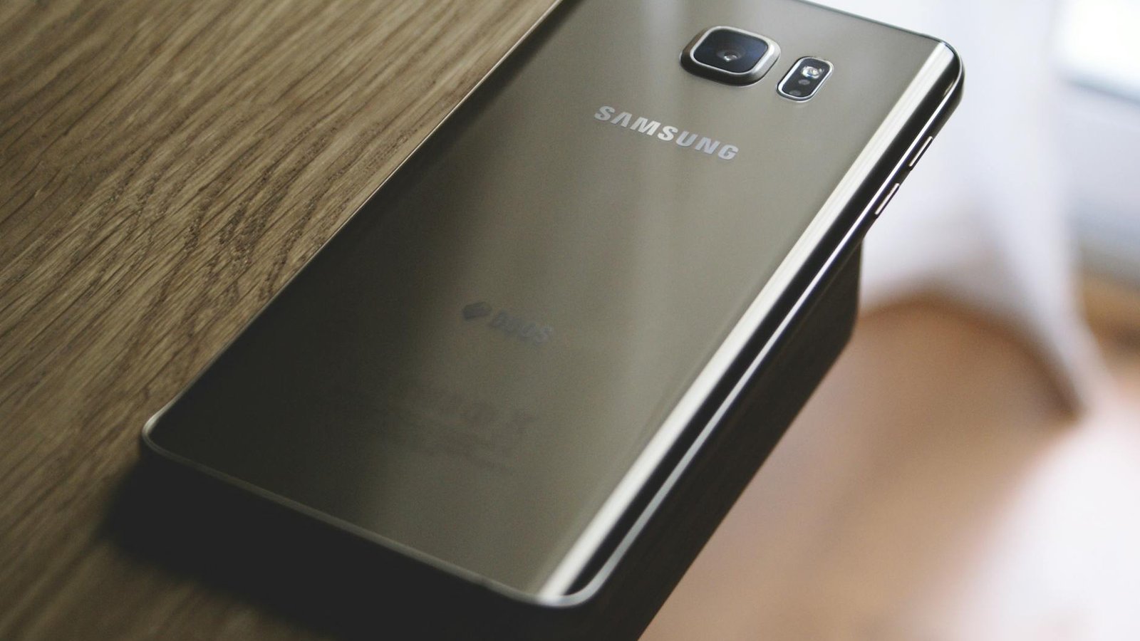Samsung Galaxy Note Edge écran allumé posé sur bois avec paysage hivernal