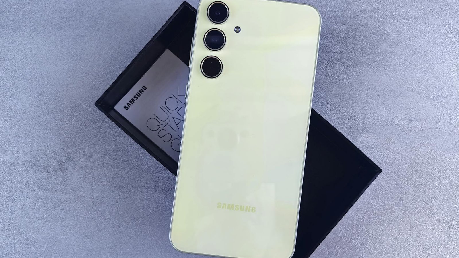 Samsung Galaxy A55 coloris jaune citron posé sur boîte noire Samsung