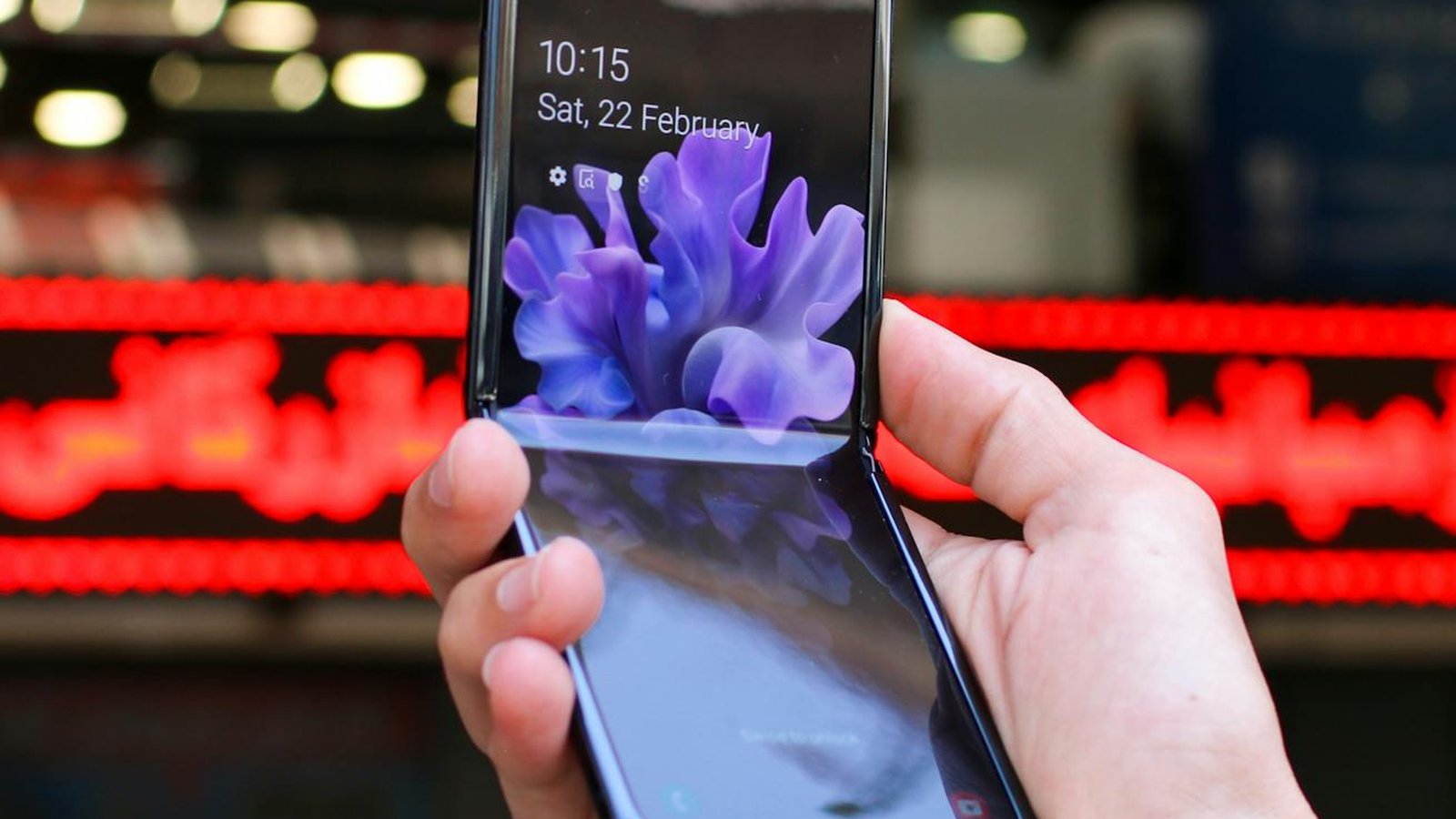 Samsung Galaxy Z Flip pliable tenu en main, écran allumé