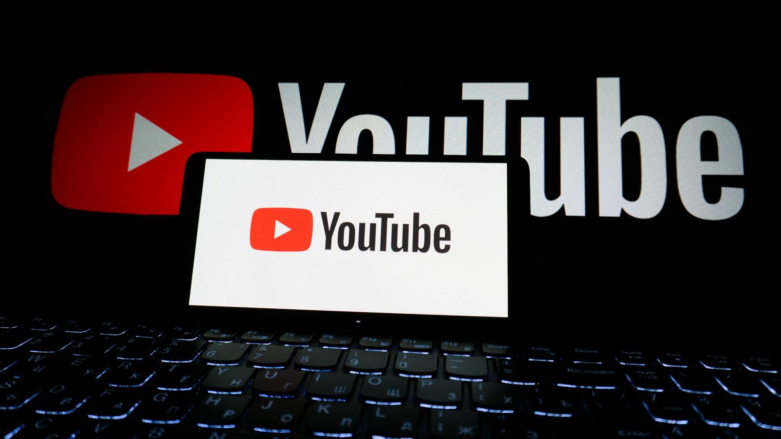 Logo YouTube sur smartphone et écran, addiction réseaux sociaux