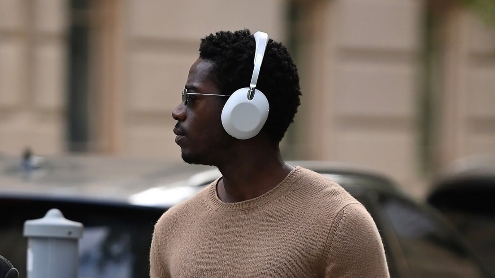 Casque audio haut de gamme blanc porté par un homme en ville, style Sony ou AirPods Max