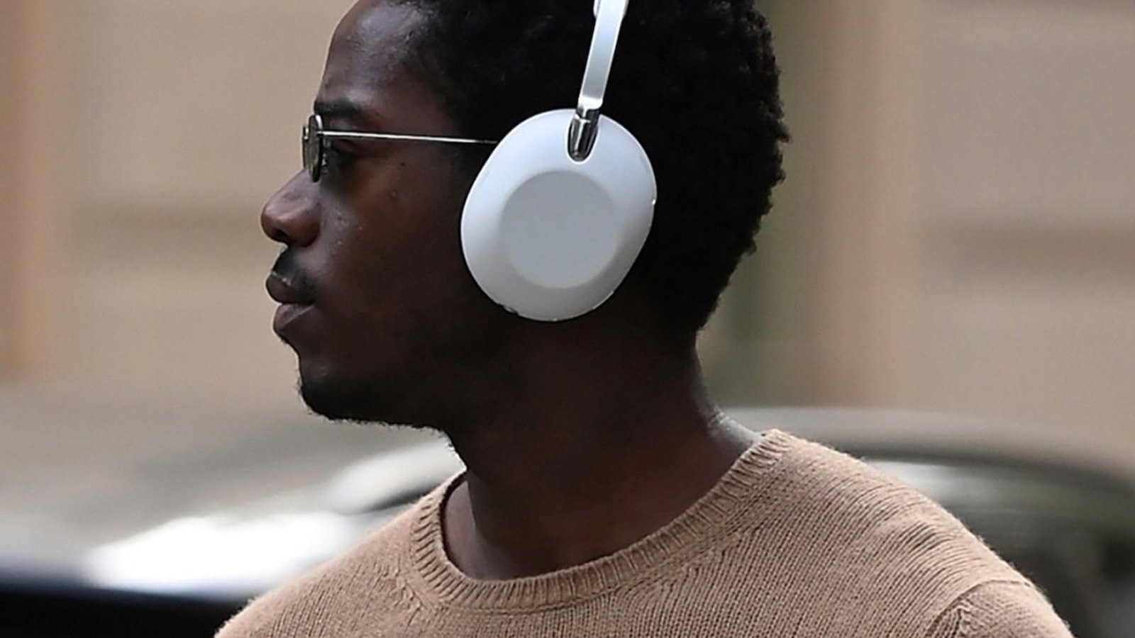 Casque Sony premium blanc sur-oreille, vue de profil rapprochée en contexte urbain