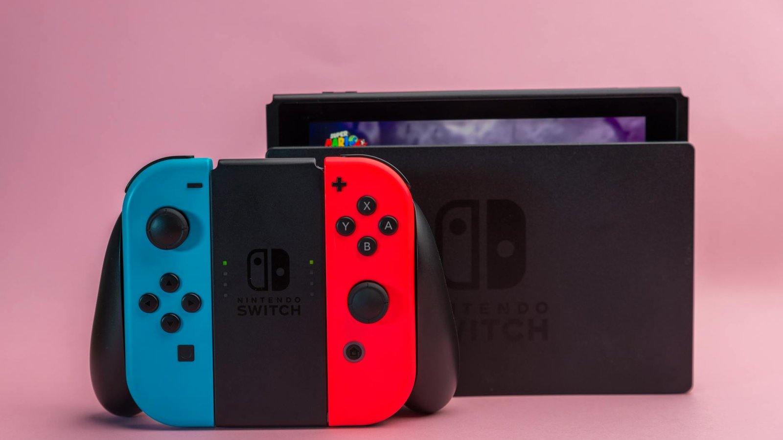 Nintendo Switch avec dock et manettes Joy-Con bleu rouge, logo Nintendo visible