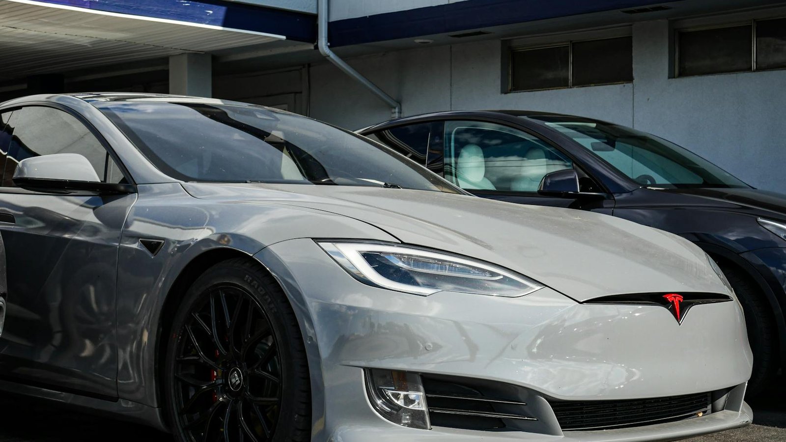 Tesla Model S grise avec logo rouge sur parking