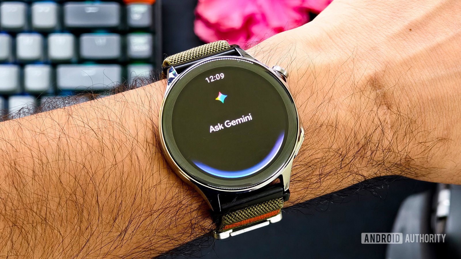 Pixel Watch affichant Ask Gemini sur poignet avec bracelet kaki