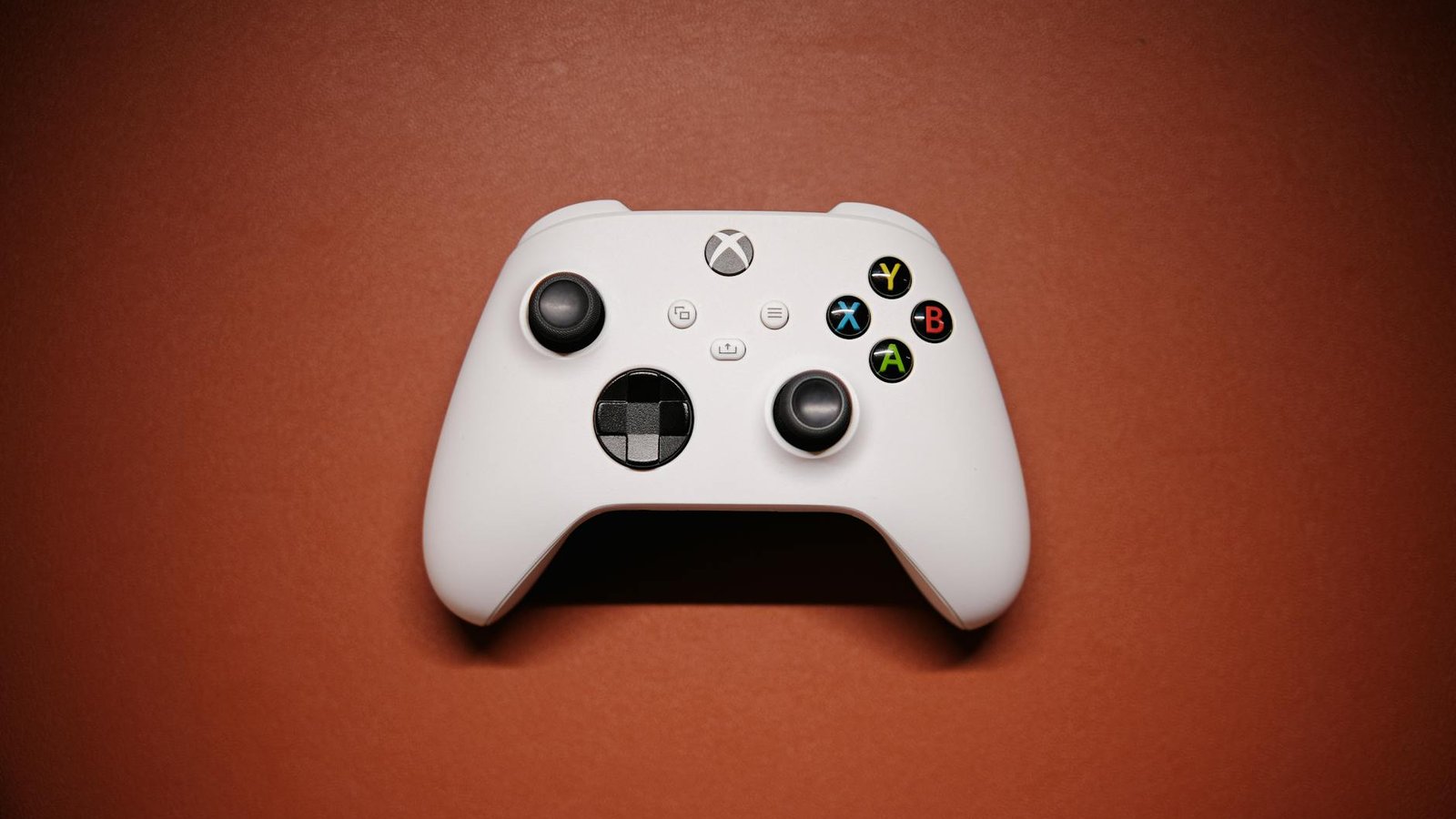 Manette Xbox blanche sur fond rouge, console Xbox Copilot IA